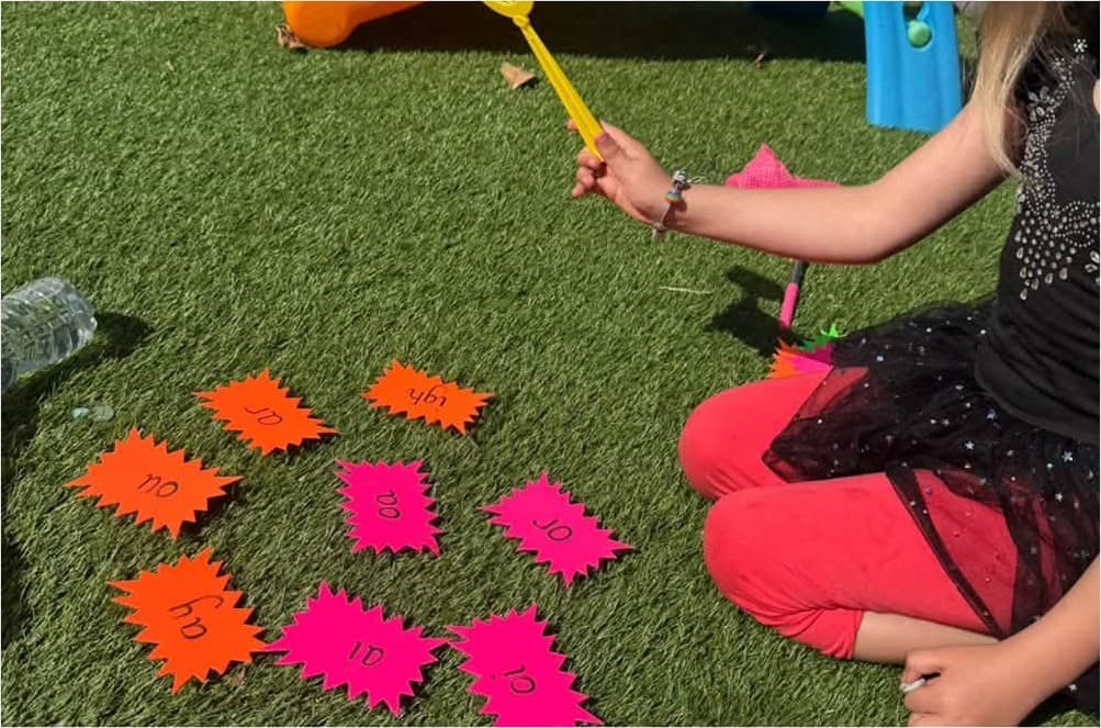 A phonics sounds game out on the grass