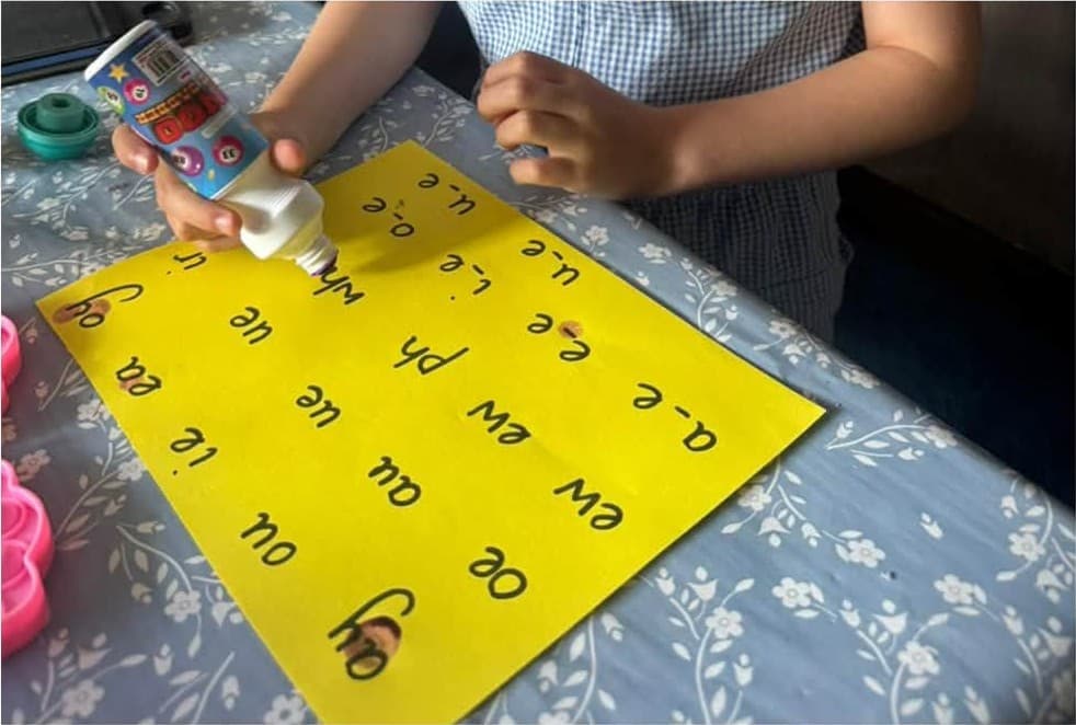 Dotting phonics sounds on a bright chart