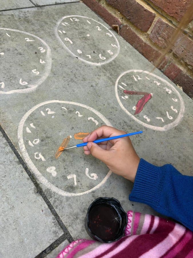 Painting the hands on chalk pavement clocks