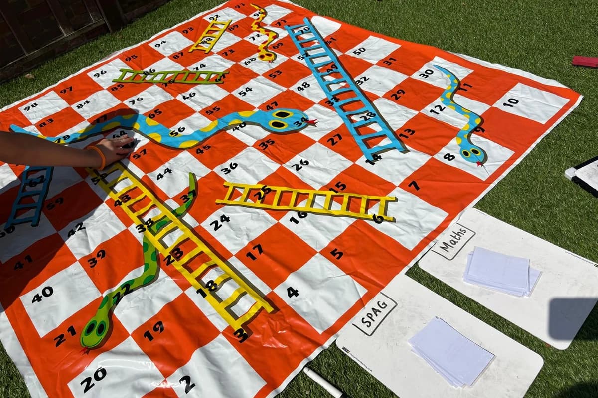 A giant snakes and ladders game with maths cards